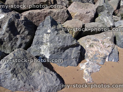 Stock image of large grey limestone rocks providing beach sea defence