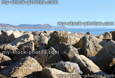 Stock image of rocks preventing erosion of beach, riprap limestone rock armour