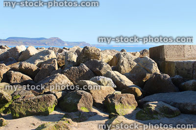 Stock image of coastal sea defence on sandy beach, natural rock armour