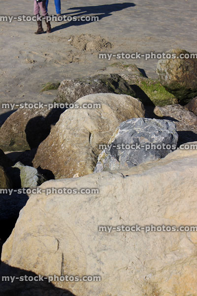 Stock image of large rocks / boulders forming sea defence on sandy beach