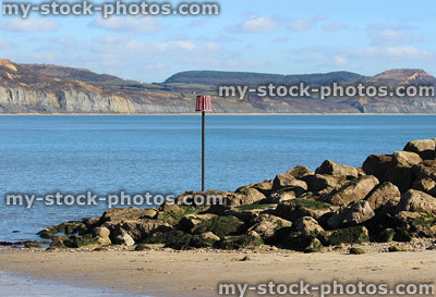 Stock image of rocky sea defence on beach, coastal erosion rock armour