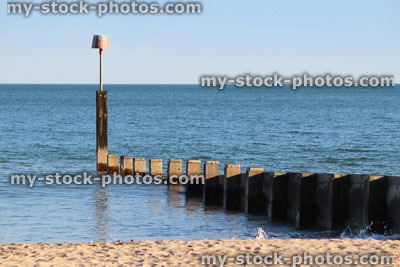 Stock image of wooden seaside groyne on sandy beach, sea erosion