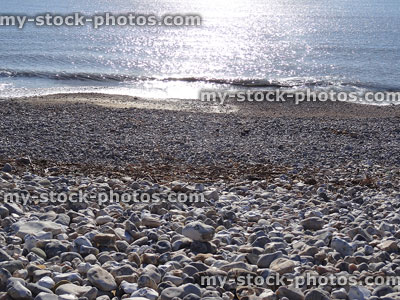 Stock image of pebbles, sand, shingle and sea at popular seaside-beach
