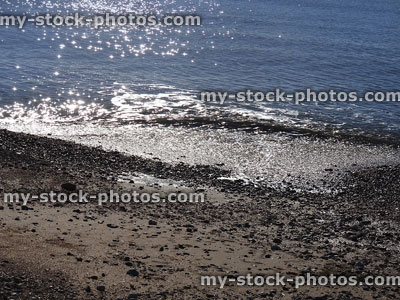 Stock image of sparkling sea in strong sunshine, pebble-beach and seaside