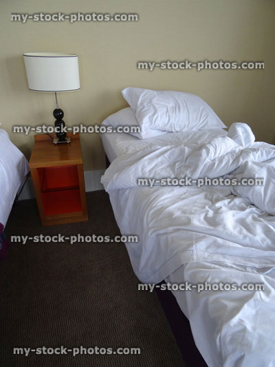 Stock image of unmade, crumpled bed sheets, twin bedroom, messy bed