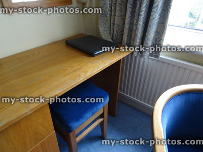 Stock image of wooden work desk in bedroom, stool, chair, office space