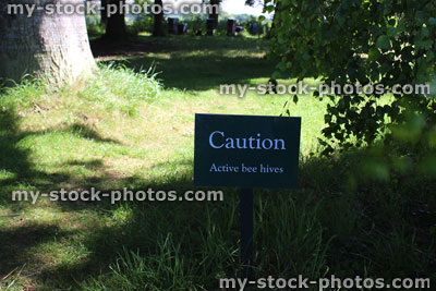 Stock image of garden sign / signpost saying 'Caution, active bee hives'