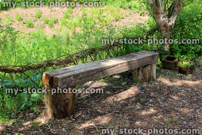 Stock image of rustic wooden bench / garden seat with willow weaving hedge