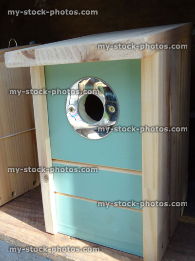 Stock image of stylish wild-bird nest box with painted-front, metal entrance-hole