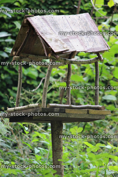 Stock image of rustic wooden bird table in garden / homemade bird table