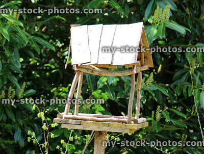Stock image of homemade wooden birdtable in garden, feeding wild birds