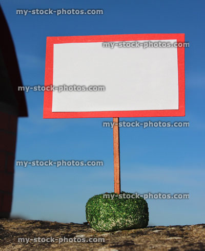 Stock image of cardboard model house, blank sign / signpost / placard, real estate, estate agent, property market