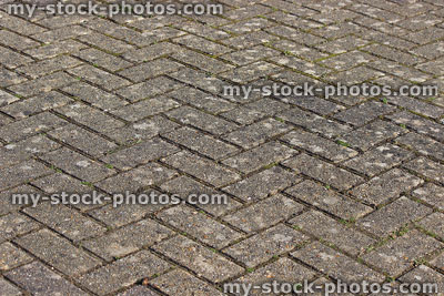 Stock image of old block paved driveway with herringbone brick pattern