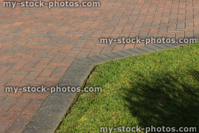 Stock image of brick paved drive and edging next to front lawn