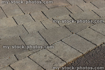 Stock image of grey block paved drive with brick edging on angle