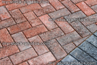 Stock image of red brick block paving on modern driveway / drive, herringbone pattern