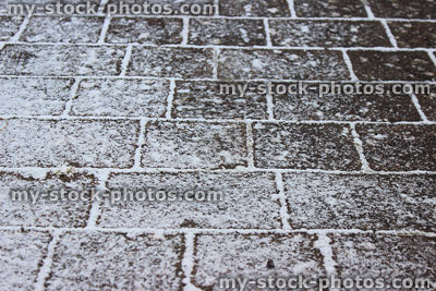 Stock image of frosty block paved driveway in the winter, with snow