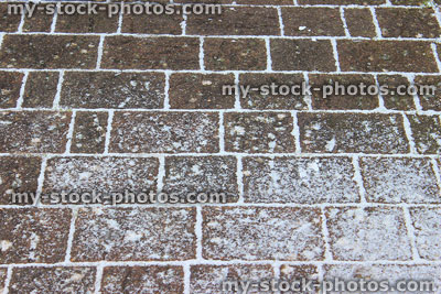 Stock image of paving blocks / brick driveway covered with light snow