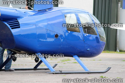 Stock image of small blue helicopter at airfield / airport, landing, refueling