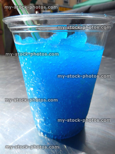 Stock image of blue frozen slushie drink with straw, snow cone ice drink, slush