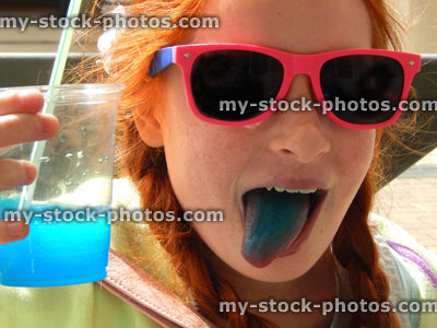 Stock image of girl drinking slushie drink with straw, frozen ice drink, blue tongue