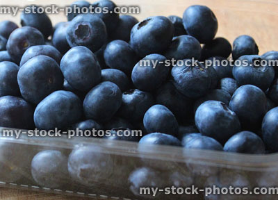 Stock image of fresh organic blueberries in plastic punnet, healthy breakfast