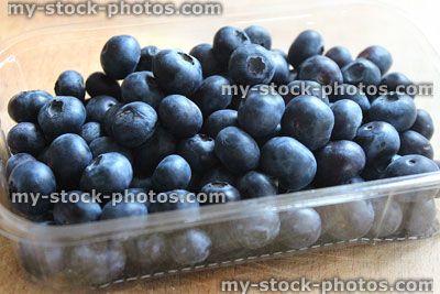 Stock image of fresh organic blueberries in plastic punnet, healthy breakfast