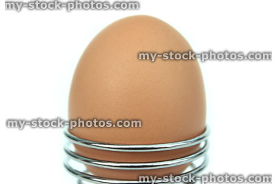 Stock image of boiled egg, stylish chrome metal, coiled spring egg cup