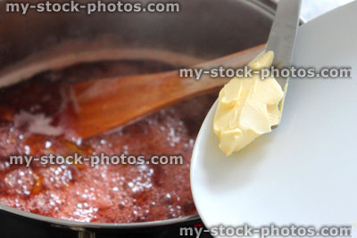 Stock image of jam making, boiling plum / strawberry jam, saucepan, adding butter, dispersing scum