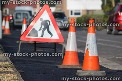 Stock image of new tarmac asphalt pavement with bollards / warning sign