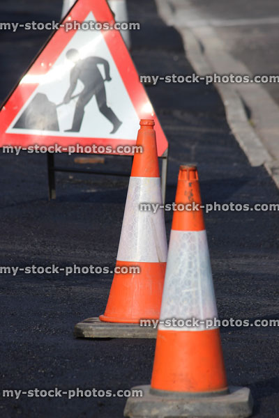 Stock image of resurfaced tarmac asphalt pavement / sidewalk, bollards, men at work sign