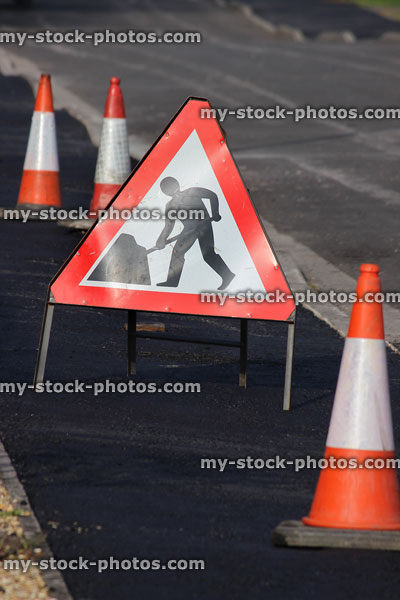 Stock image of triangle shaped 'men at work' warning sign, bollards