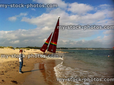 Stock image of red head teenage boy stood on beach near a boat