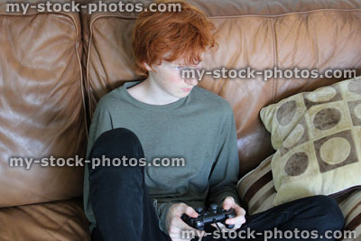 Stock image of boy playing computer game, gaming controller, video game