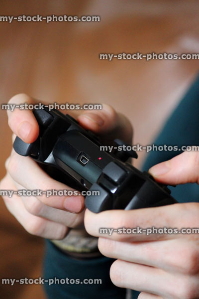 Stock image of boy playing on video computer game controller joysticks