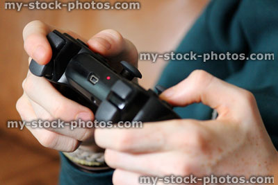 Stock image of teenager playing computer video game with wireless gaming controller