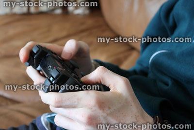 Stock image of teenager playing on video game controller with joystick