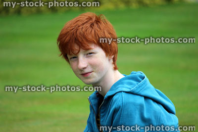 Stock image of young boy with short red hair smiling in garden, laughing, fun