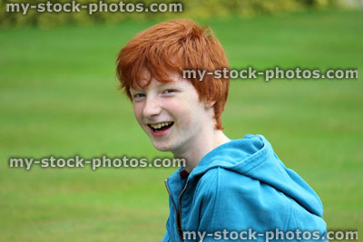 Stock image of young boy with short red hair smiling in garden, laughing, fun
