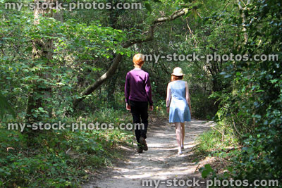 Stock image of boy and girl walking along woodland pathway / footpath