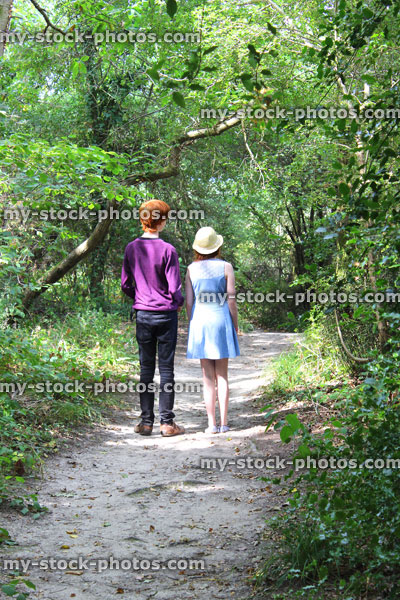 Stock image of boy and girl walking along woodland pathway / footpath