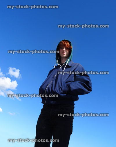 Stock image of boy wearing hoodie and blue jacket, looking at camera