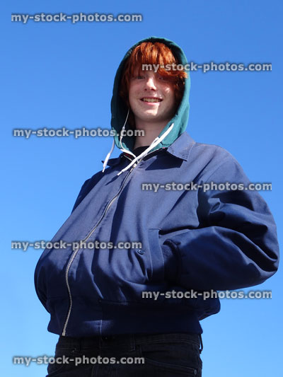 Stock image of boy with hoodie and jacket, smiling, looking at camera