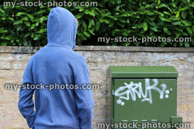 Stock image of teenage boy / youth wearing hoodie, beside wall