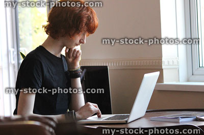 Stock image of boy surfing Internet on laptop-computer for school homework