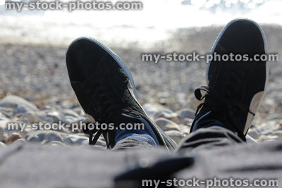 Stock image of man sunbathing on beach in winter, feet view