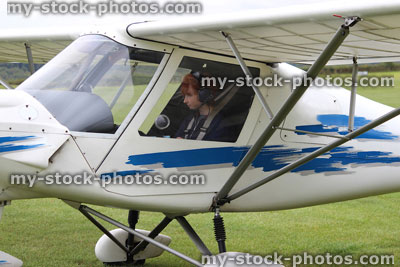 Stock image of teenage boy in plane cockpit, having flying lesson, airfield / airport