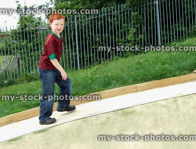 Stock image of young boy walking up hill in playground