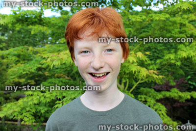 Stock image of happy boy in garden, short red hair, smiling, laughing