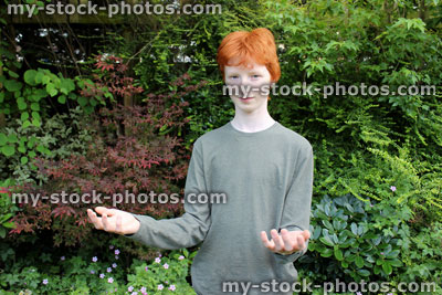Stock image of teenage boy holding out hands / arms, pretending to lift